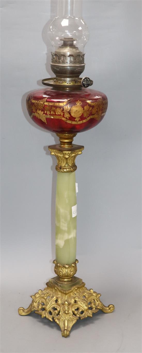 An ormolu and onyx oil lamp with cranberry reservoir